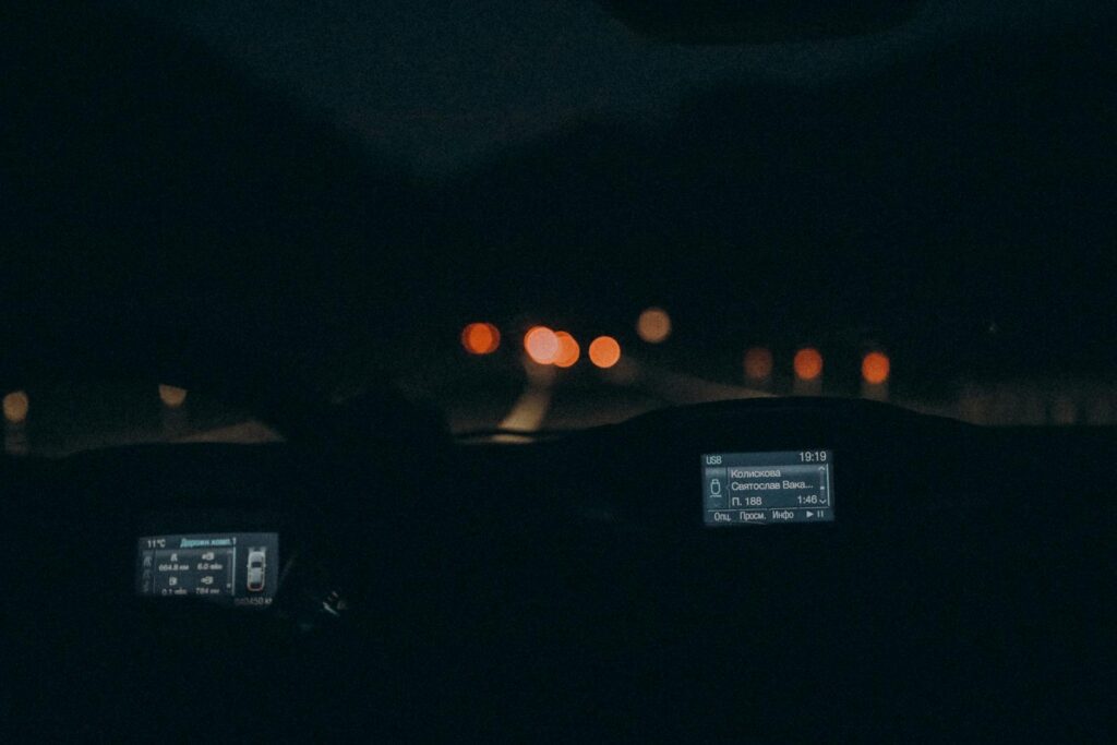 Experience the serene ambiance of night driving with this car interior view featuring a dimly lit dashboard.