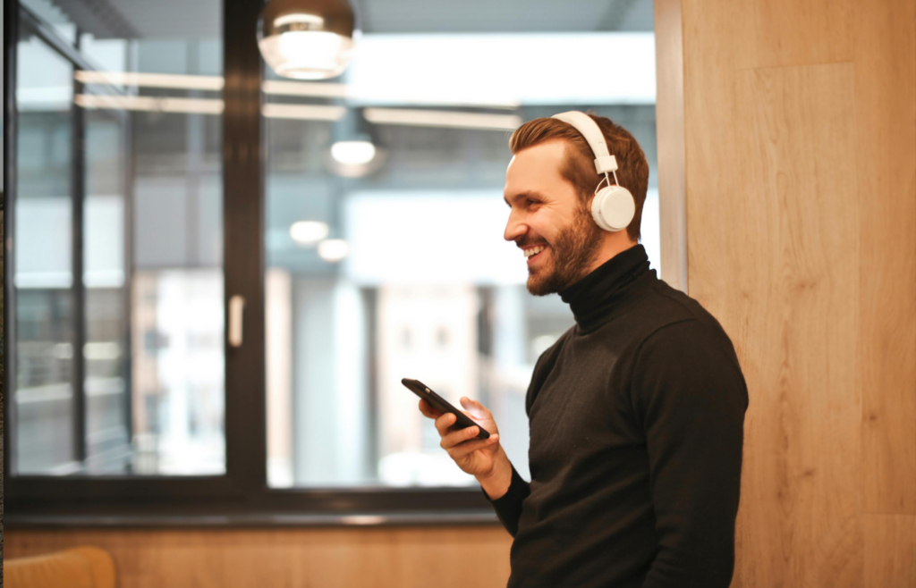 A person laughing while holding a phone