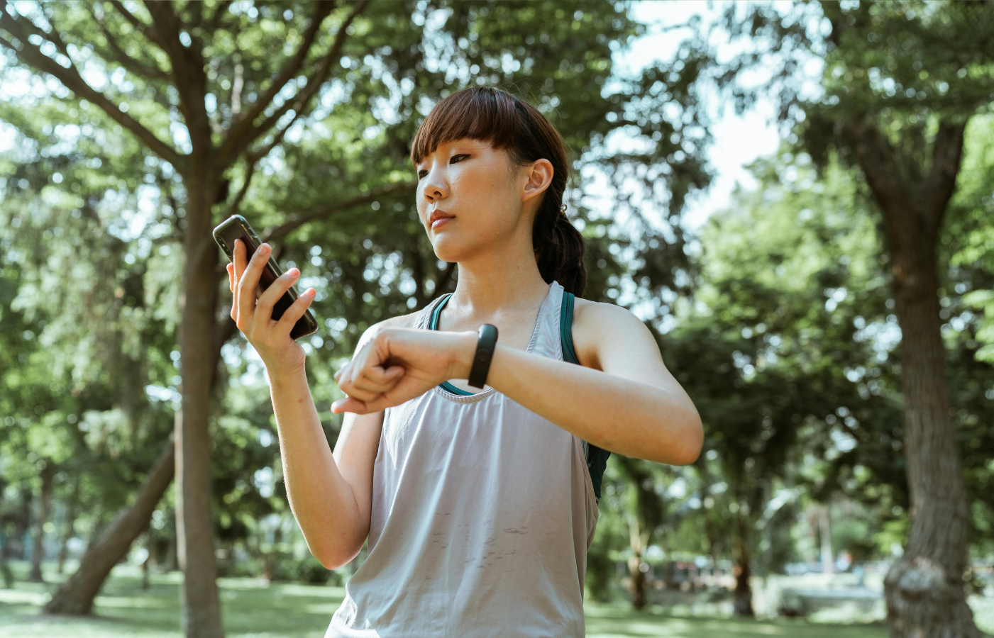 A woman jogging while wearing a smartwatch and using smartphone
