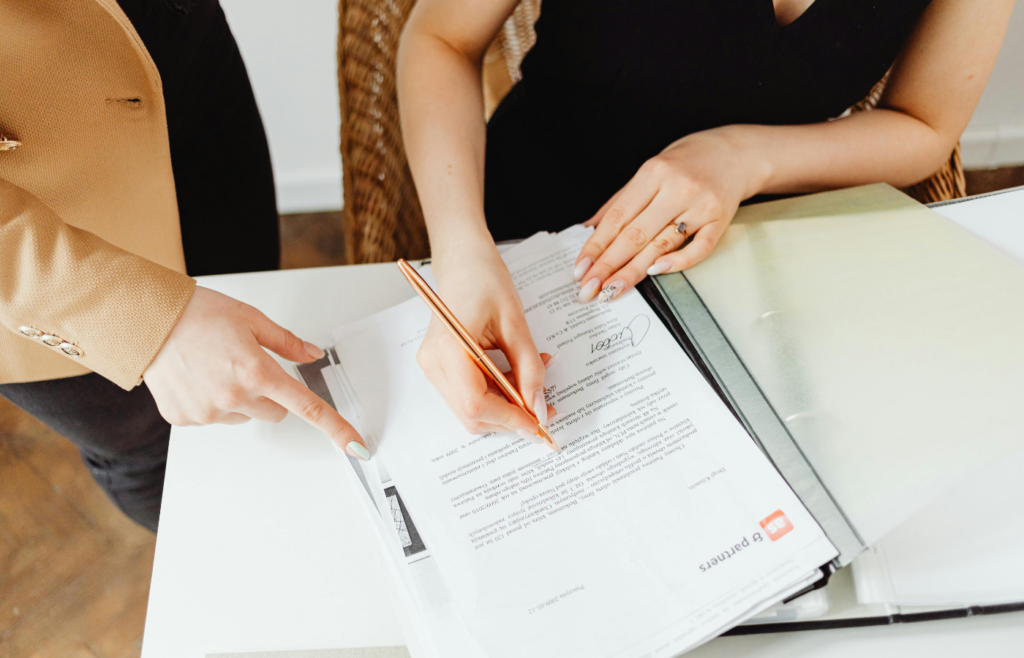 A dealer pointing at a contract with hidden fees