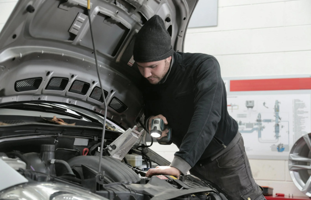 A mechanic checking oil under the hood