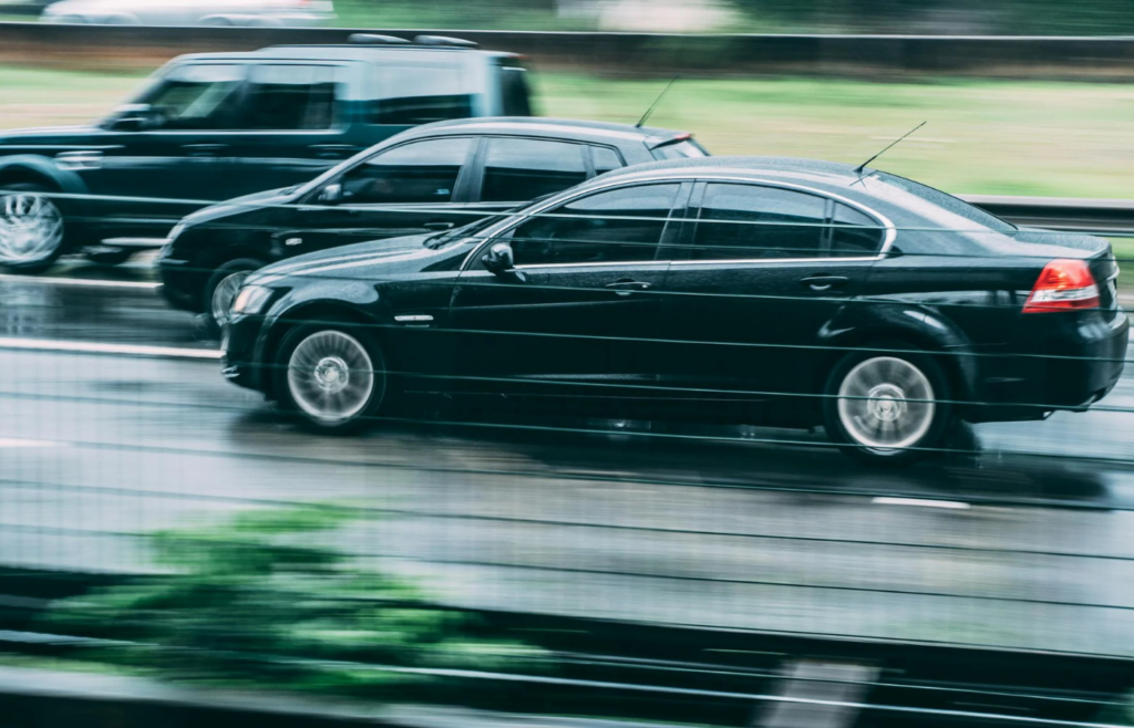 A large SUV next to a smaller sedan on the road