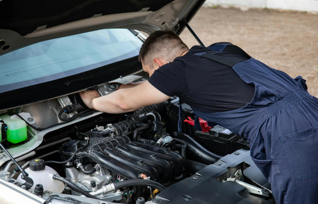 A car in an independent repair shop with a mechanic working