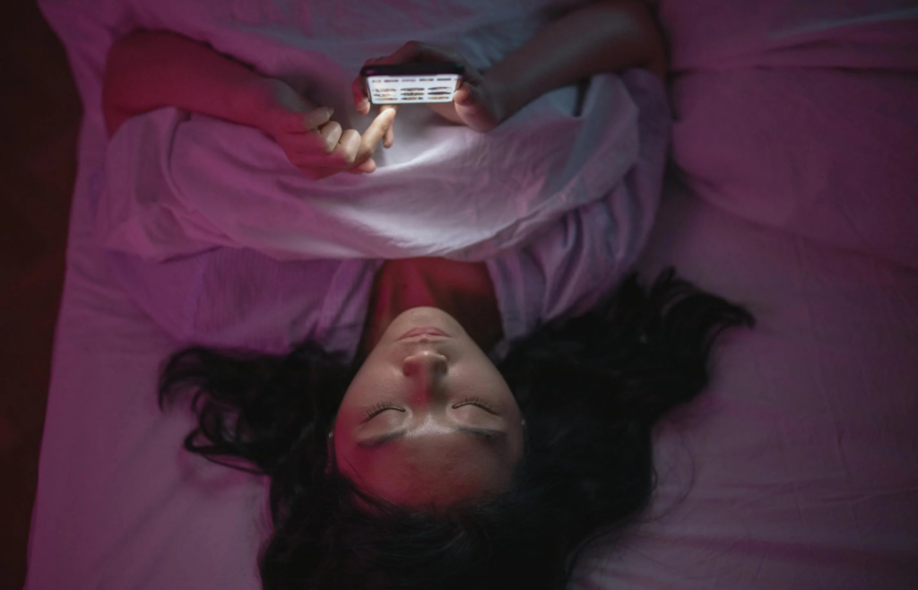 Person checking phone late at night in bed