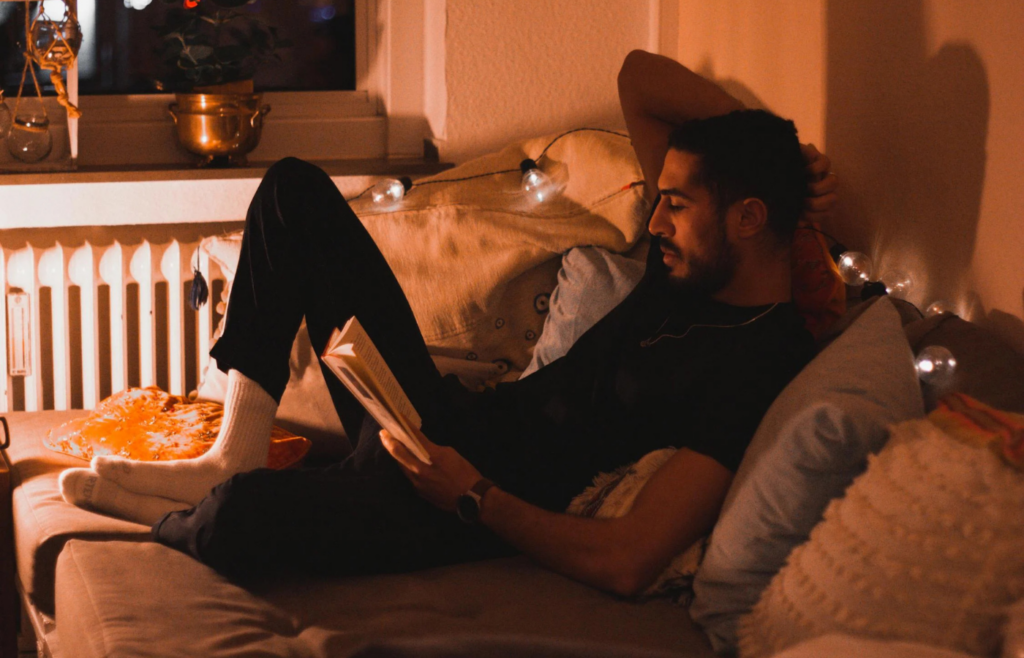 Person relaxing with a book in the evening