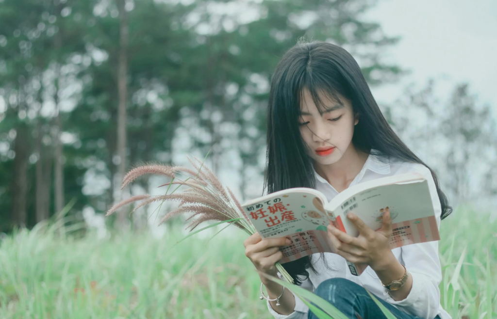 Person reading a book outdoors