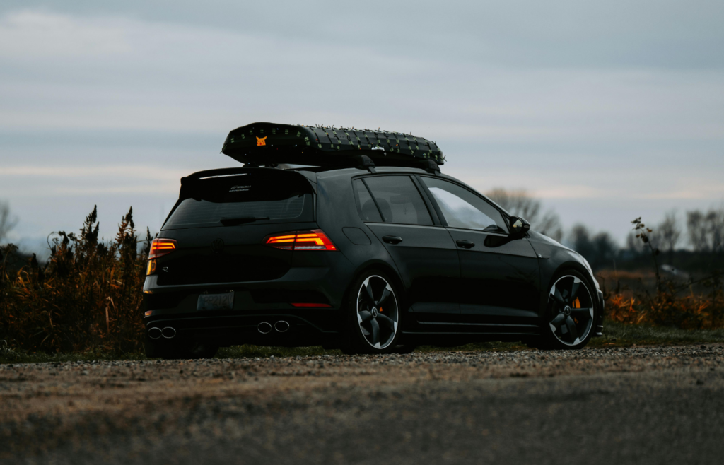 Sleek Black Car Outdoors with Roof Storage at Twilight