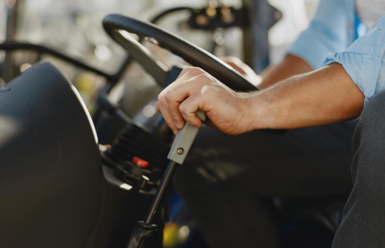 Close up of a Steering Wheel and Mans Hand on a Gear