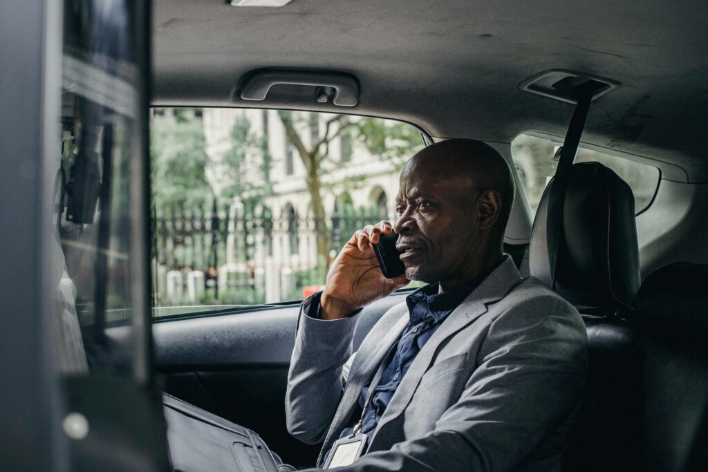 Serious black man speaking on smartphone in car